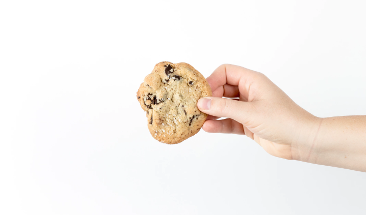 A hand offering a cookie